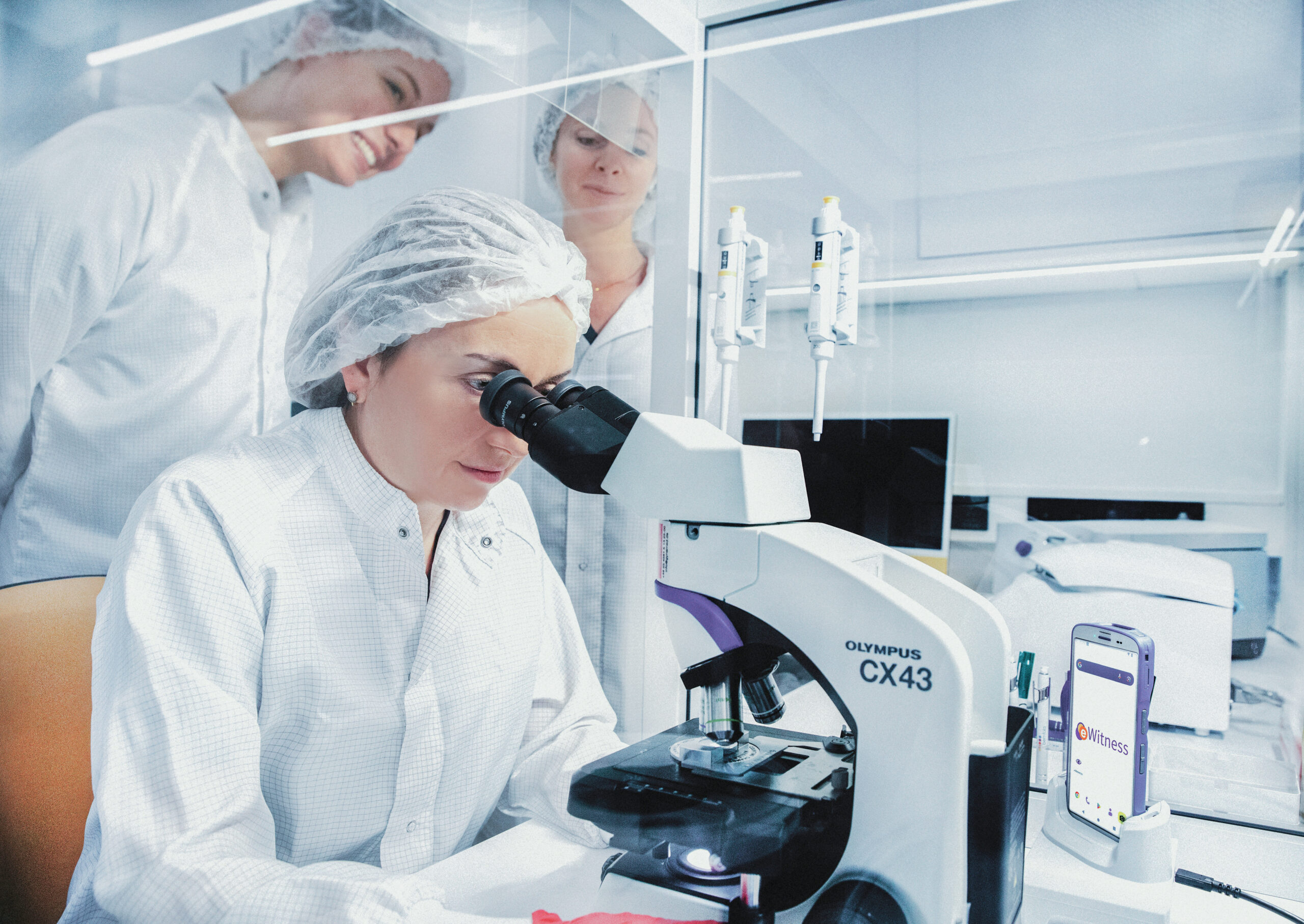 Embryologie-Team im IVF-Labor mit Schutzkleidung bei der Arbeit an Proben.