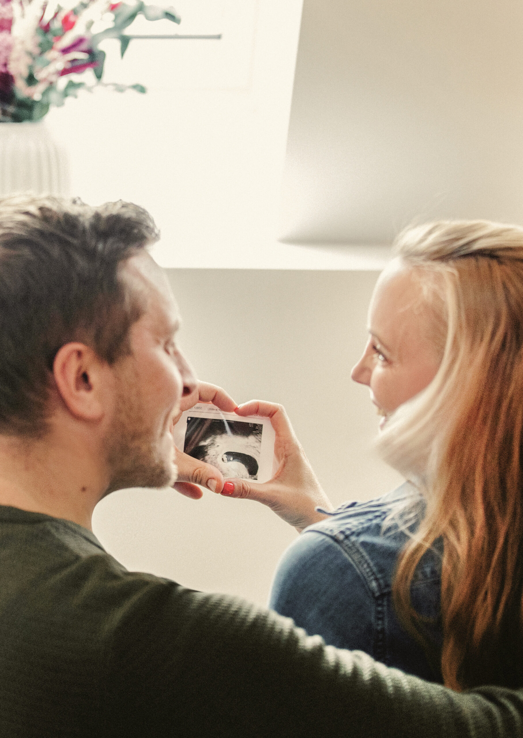 Ein Paar betrachtet gemeinsam ein Ultraschallbild – voller Hoffnung und Vorfreude.