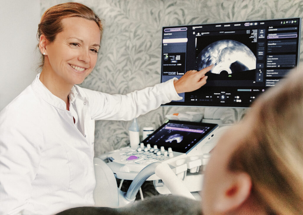Ärztin Dr. Corinna Mann erklärt ein Ultraschallbild am Monitorim Beratungsgespräch.